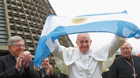 Papst Franziskus hält eine Argentinien-Flagge in die Luft (KNA)
