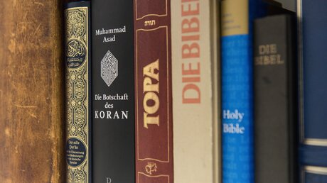 Koran, Thora und Bibel  / © Elisabeth Schomaker (KNA)