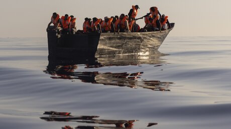 Migranten in einem Holzboot während einer Rettungsaktion im Mittelmeer / © Jeremias Gonzalez (dpa)