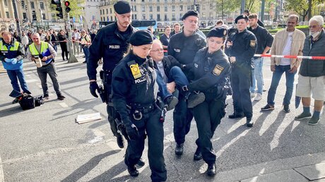 Polizisten tragen Jörg Alt von einer Straßenblockade weg / © Christian Wölfel (KNA)