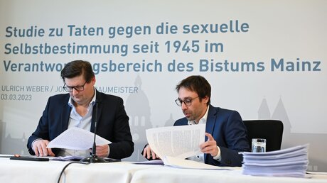 Die Rechtsanwälte Ulrich Weber (l) und Johannes Baumeister besprechen sich vor Beginn einer Pressekonferenz zu den Ergebnissen einer Studie zu sexuellem Missbrauch im Bistum Mainz / © Arne Dedert (dpa)