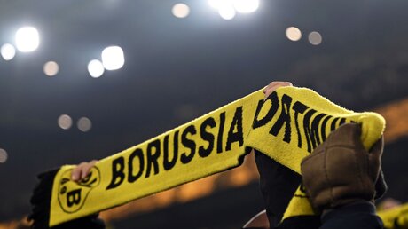 Fans von Borussia Dortmund halten vor dem Spiel einen Schal hoch / © Bernd Thissen (dpa)