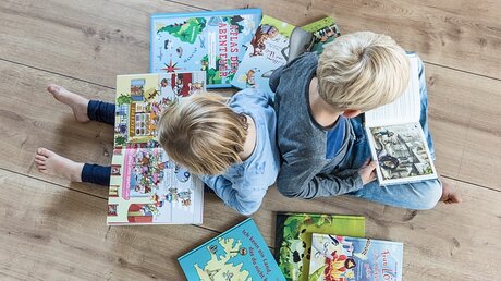 Lesende Kinder mit Bilderbüchern / © Elisabeth Schomaker (KNA)