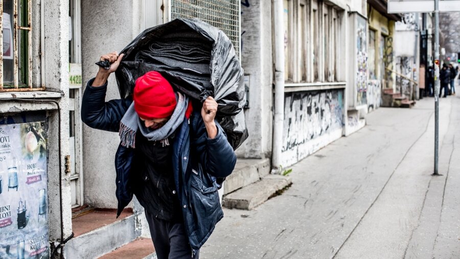 Ein Mann trägt einen Sack mit Decken / © Janossy Gergely (shutterstock)