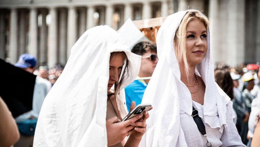Junge Frauen, die ihren Kopf mit weißen Tüchern vor der Sonne schützen, beim Angelus-Gebet auf dem Petersplatz im Vatikan / © Cristian Gennari/Romano Siciliani (KNA)