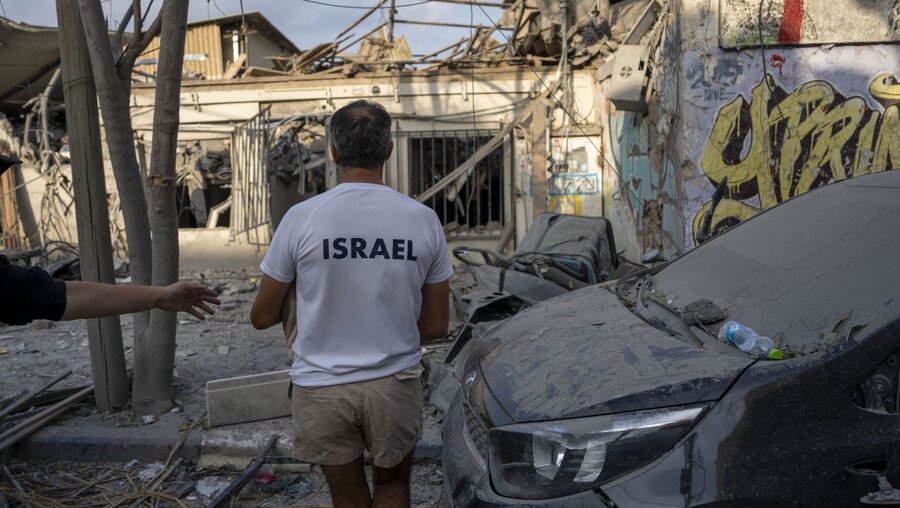 Israelis inspizieren die Trümmer eines Gebäudes, einen Tag nachdem es von einer aus dem Gazastreifen abgefeuerten Rakete getroffen wurde / © Oded Balilty/AP (dpa)