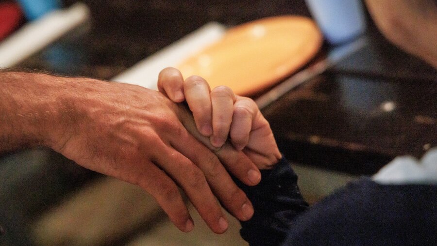 Zwei Hände von einem Freiwilligen und einer betreuten Person aus Kfar Rafael in Tabgha / © Andrea Krogmann (KNA)