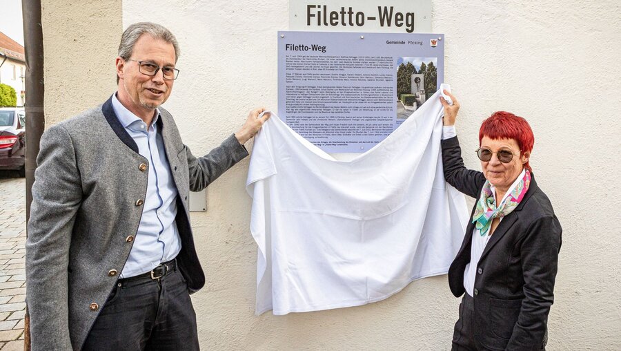 Rainer Schnitzler, Bürgermeister von Pöcking, und die Historikerin Marita Krauss enthüllen am 25. Mai 2023 in Pöcking ein Schild mit der Aufschrift "Filetto-Weg" und eine Gedenktafel / © Robert Kiderle (KNA)