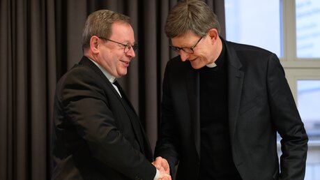 Handschlag: Bischof Georg Bätzing und Kardinal Woelki / © Robert Michael (dpa)