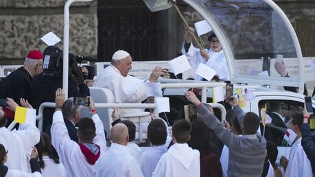 Papst Franziskus kommt im Papamobil zu einer Heilige Messe. / © Andrew Medichini/AP (dpa)