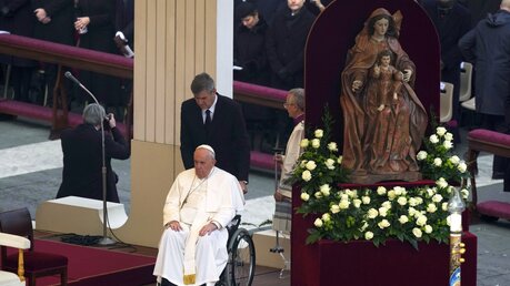 Papst Franziskus kommt im Rollstuhl zur öffentlichen Trauermesse für den emeritierten Papst Benedikt XVI. auf dem Petersplatz. / © Antonio Calanni/AP (dpa)