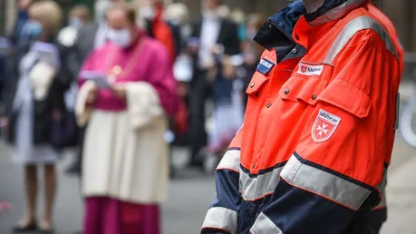 Person mit einer Jacke des Malteser Hilfsdienstes bei einem Gottesdienst / © Harald Oppitz (KNA)