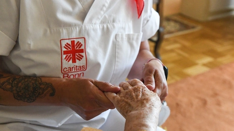 Eine Pflegerin massiert die Hände einer Seniorin / © Harald Oppitz (KNA)
