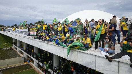 Brasilia: Anhänger des ehemaligen brasilianischen Präsidenten Bolsonaro stehen auf dem Dach des Kongressgebäudes / © Eraldo Peres (dpa)