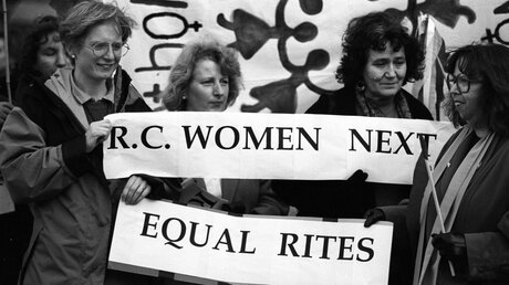 Frauen halten am 12. März 1994 in Bristol ein Banner mit der Aufschrift "R.C. Women next - Equal rites"  (KNA)