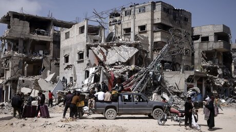 Palästinensische Gebiete, Chan Junis: Palästinenser tragen ihre Habseligkeiten, nachdem ihre Häuser bei einem israelischen Angriff zerstört wurden / © Mohammed Dahman (dpa)