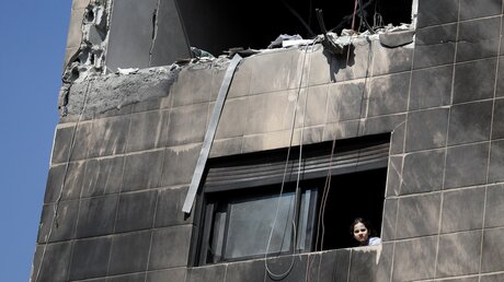 Ein Kind schaut aus einem Fenster in Damaskus, Syrien, nach einem mutmaßlich israelischen Angriff. / © Omar Sanadiki/AP (dpa)