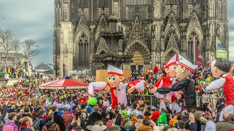 Karnevalisten am Zug vor dem Kölner Dom an Rosenmontag, den 20. Februar 2023, beim 200. Jahrestag des Rosenmontagsumzugs in Köln. / © Theo Barth (KNA)