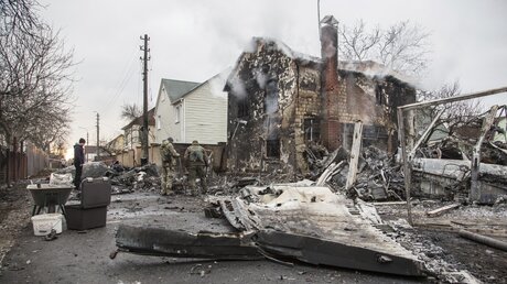 Kiew: Feuerwehrleute betrachten die Trümmer eines Flugzeugs das zwischen Häusern abgestürzt ist / © Oleksandr Ratushniak (dpa)