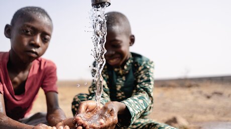 Zwei Jungen halten ihre Hände unter einen Wasserhahn / © Riccardo Mayer (shutterstock)