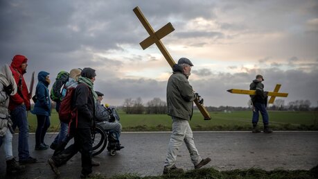 Ein Demonstrant trägt ein gelbes Kreuz bei einer Prozession von Klimaaktivisten vom Erkelenzer Ortsteil Keyenberg nach Lützerath / © Gordon Welters (KNA)