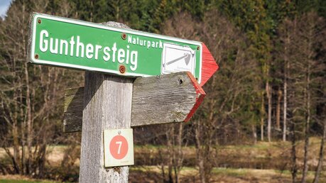 Hinweisschild mit der Aufschrift "Gunthersteig - Naturpark" am 28. März 2023 zwischen Kirchberg und Rinchnach. / © Andreas Drouve (KNA)