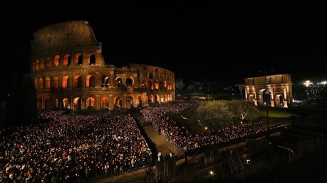  Menschen mit Kerzen am Kolosseum vor Beginn des Kreuzwegs in Rom / ©  Alessandra Tarantino (dpa)