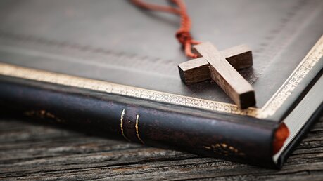 Holzkreuz auf einer Bibel / © Elena Elisseeva (shutterstock)