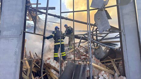 Auf diesem vom ukrainischen Katastrophenschutz zur Verfügung gestellten Foto arbeiten Rettungskräfte daran, einen Brand nach einem Angriff zu löschen. / © Uncredited/Ukrainian Emergency Service/AP (dpa)
