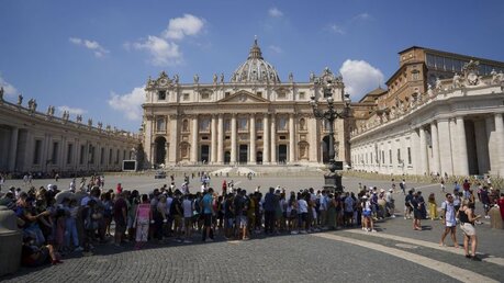Menschen warten auf dem Petersplatz auf das Mittagsgebet mit Papst Franziskus / © Andrew Medichini/AP (dpa)