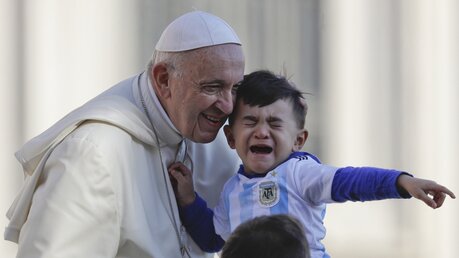 Papst Franziskus und ein kleines Kind mit einem Trikot der argentinischen Nationalmannschaft / © Gregorio Borgia (dpa)