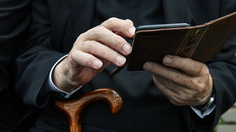 Priester mit Smartphone  / © Harald Oppitz (KNA)