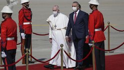 Papst Franziskus wird von Premierminister Mustafa al-Kadhimi bei seiner Ankunft auf dem internationalen Flughafen von Bagdad empfangen. / © Andrew Medichini/AP (dpa)
