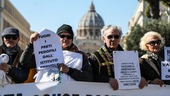 Teilnehmer einer Demonstration der Opferorganisation "Ending Clergy Abuse" (ECA) gehen am 23. Februar 2019, während des Anti-Missbrauchsgipfels, die Via della Conciliazione in Rom entlang. Im Hintergrund der Petersdom im Vatikan. (KNA)